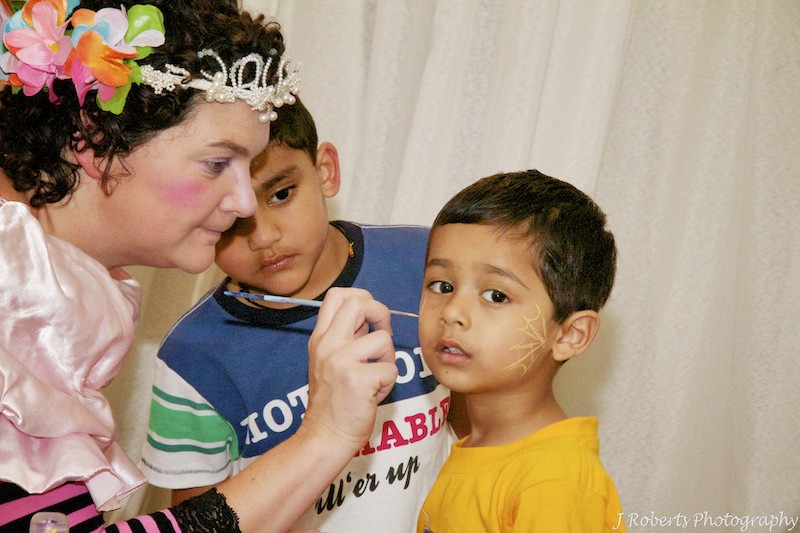 Fairy face painting a little boy at birthday party - party photography sydney